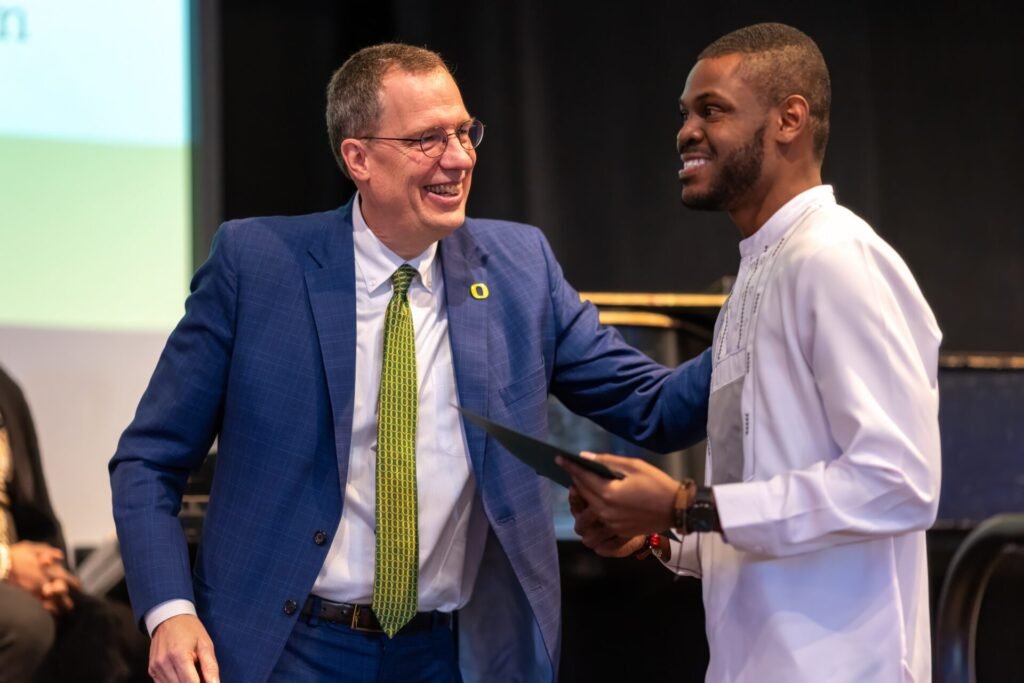 Daniel Appiah Gyekye receiving the 2025 Rev. Dr. Martin Luther King Jr. Student Leadership Award from University of Oregon President Karl Scholz