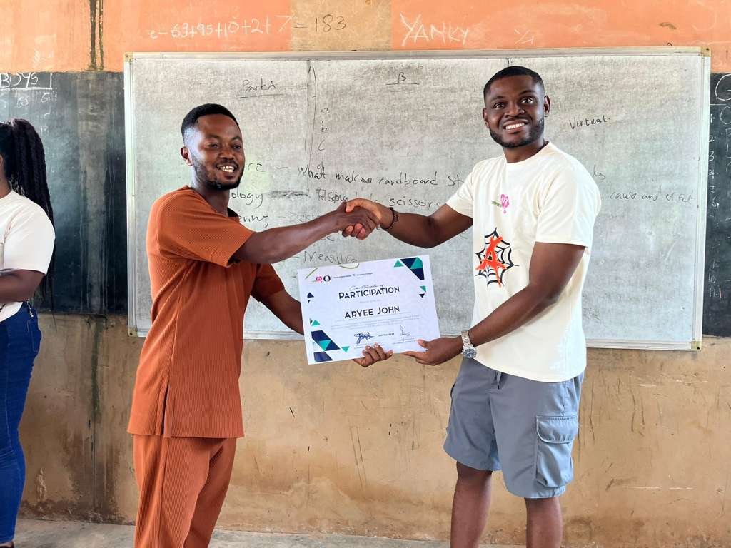 Daniel Appiah Gyekye presenting a certificate to a teacher in Krutiase, Ghana